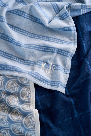 Blue and white striped lightweight blanket with tile pattern detail and embroidered logo.2