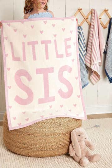Cream-colored mini blanket with pink heart pattern and "LITTLE SIS" text, pink trim edge.5
