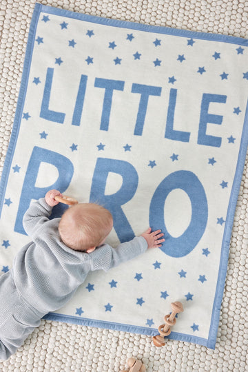 Blue and cream mini blanket with "LITTLE BRO" text and scattered stars, displayed with infant.6