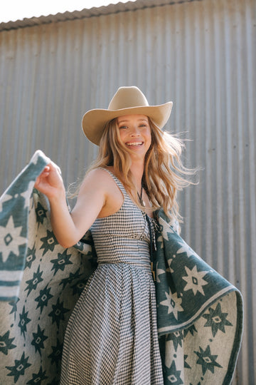 Lightweight blanket with cream and teal star pattern, displayed across shoulders of a person wearing a cowboy hat.2