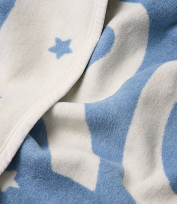 Blue and cream fleece blanket with star and cloud pattern and white binding edge detail.3