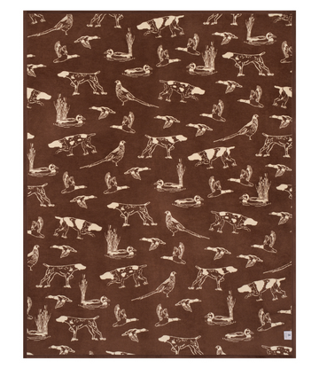 Brown blanket with cream-colored repeating pattern of hunting dogs, flying birds, and cattails throughout.8