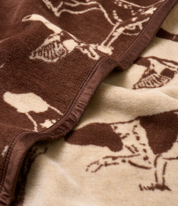 Brown and cream blanket with bird dog jacquard pattern and sewn edges.7