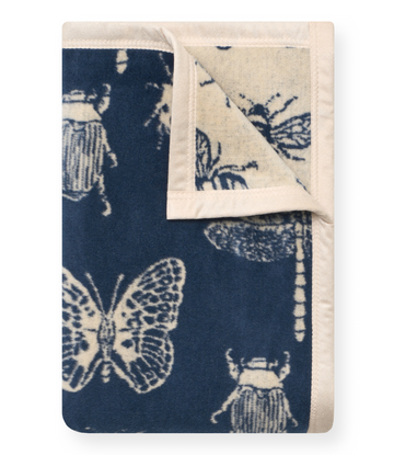 Navy and cream midi blanket with scattered butterfly and insect print design, rolled corner detail visible.6