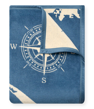 Blue and cream blanket with compass rose design and Cape & Islands map pattern, partially folded.3
