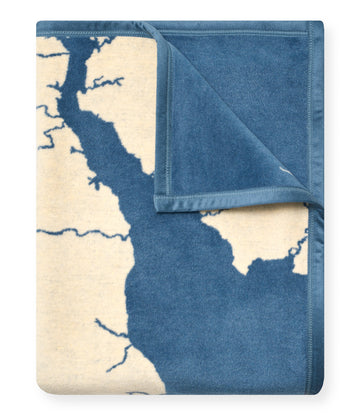 Folded blanket with blue and cream Chesapeake Bay map design and coordinating solid blue reverse side.4