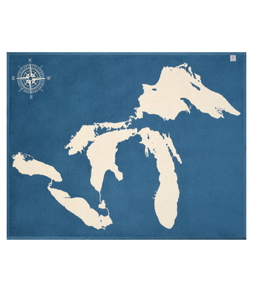 Blue blanket with cream-colored Great Lakes map and compass rose design.5