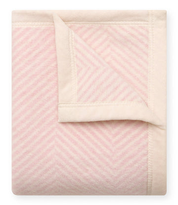 Pink and cream herringbone patterned mini blanket with cream binding and folded corner detail.3