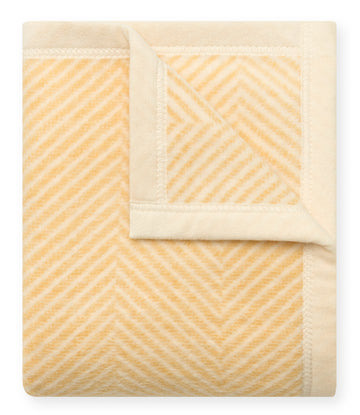 Butter yellow and cream mini blanket with herringbone pattern and white binding edges.3