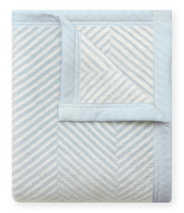 Light blue and cream herringbone patterned mini blanket folded to show woven texture detail.7