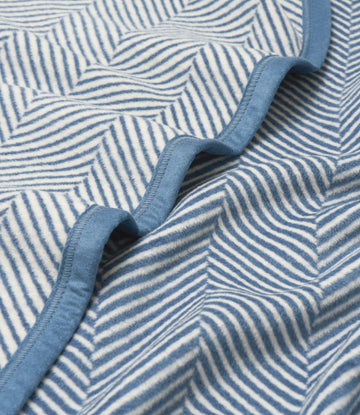 Cornflower blue and white herringbone patterned blanket with bound edge detail.4