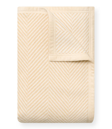 Cream blanket with diagonal herringbone stripe pattern and solid binding along edges.3