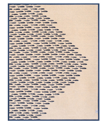 Cream and navy blanket with repeating fish pattern on left side fading to solid cream on right, navy border.7