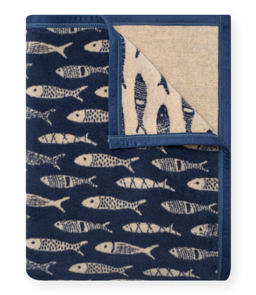 Navy blue blanket with cream-colored fish pattern throughout, folded to show both sides with navy binding.5
