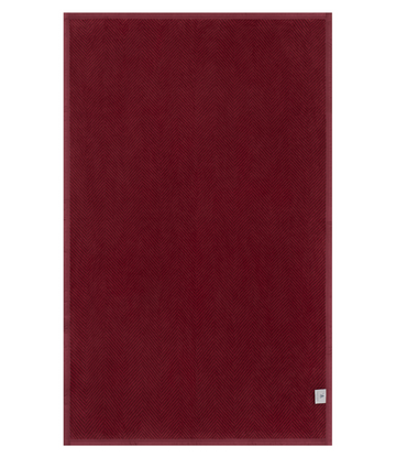 Cranberry-colored midi blanket with herringbone weave pattern and woven label at bottom corner.8