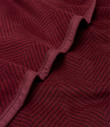 Cranberry blanket with herringbone weave pattern and stitched binding detail, folded to show texture.4