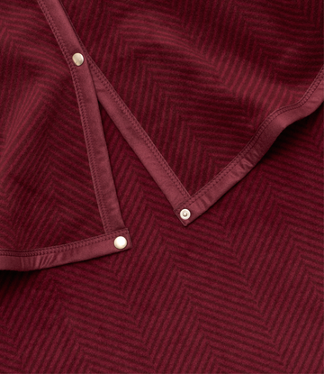 Cranberry tree skirt with herringbone pattern and cream-colored snap closures.3