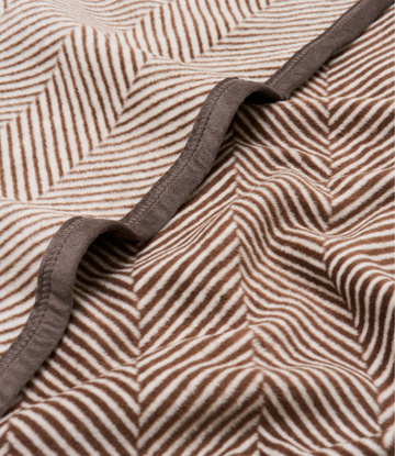 Brown and cream herringbone patterned blanket with charcoal binding detail folded to show texture.5