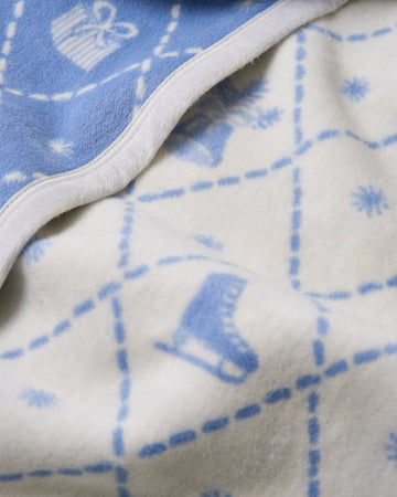 Blue and cream reversible blanket with holiday motifs including stockings and ornaments, white binding edge.3
