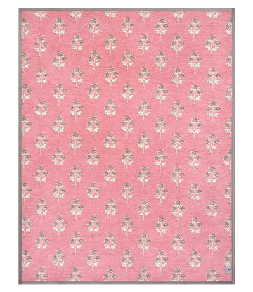 Pink blanket with repeating cream and tan blockprint hydrangea flower pattern and gray border.9