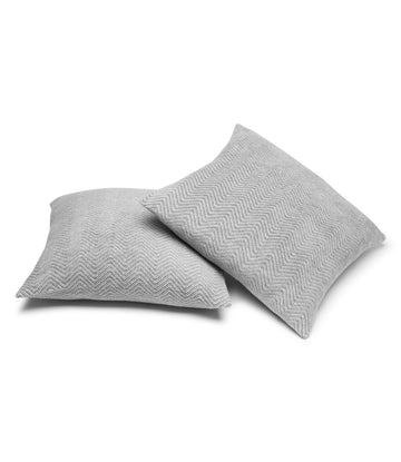 Two gray throw pillow covers with herringbone weave pattern displayed at an angle.3