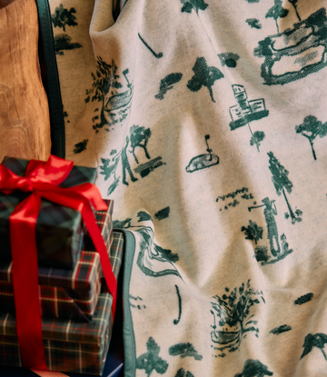 Cream blanket with dark green forest and wildlife motifs including trees, animals, and cabins.5