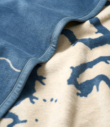 Blue fleece blanket with navy lake map pattern on cream background and binding edge detail.3