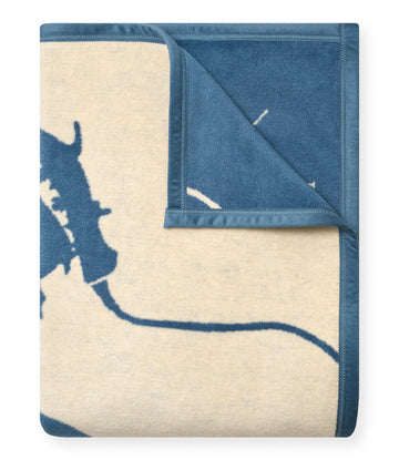 Blue and cream woven blanket with Lake Travis map design, one corner folded to show reverse side.4