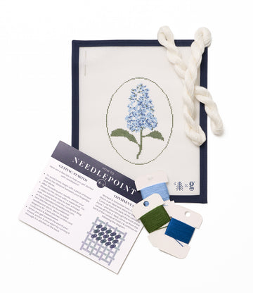Needlepoint kit with pre-printed canvas showing blue lilac flowers, instruction sheet, cream thread, and green and blue embro3