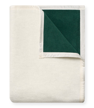 Cream and dark green blanket with white trim, folded to show both solid sides.4
