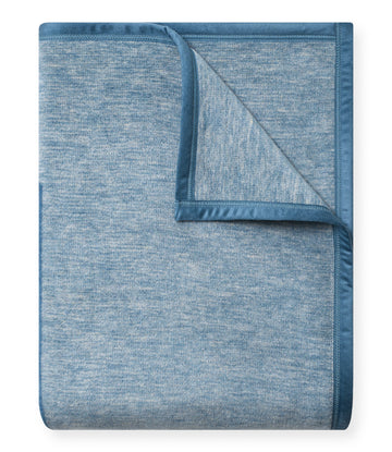 Blue textured blanket with darker binding around edges, shown folded with corner turned back to display interior texture.4