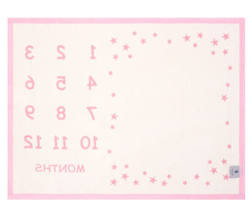 Small pink and cream blanket with milestone markers and scattered stars printed throughout.8