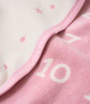 Pink and cream blanket with star pattern and white number printing, showing sewn binding edge detail.3