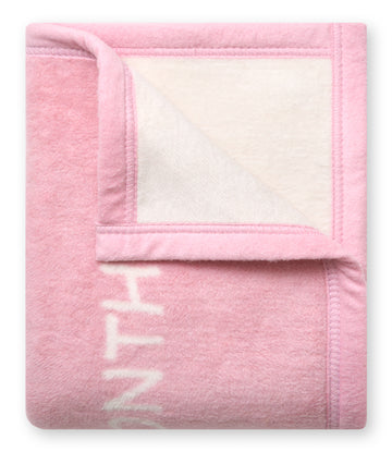 Pink fleece blanket with cream-colored border and milestone marker panel on lower section.7