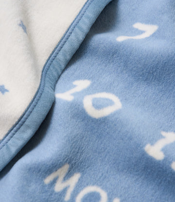 Blue and white fleece blanket with cloud pattern, showing folded edge and cream-colored reverse side.3