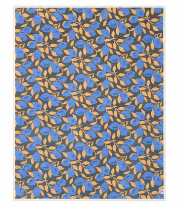 Blanket with all-over pattern of blue lemons and gold leaves on dark gray background.6