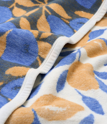 Yellow and blue lemon leaf pattern blanket with white binding edge detail.5