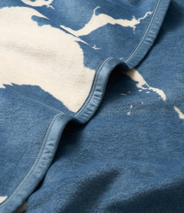 Blue and cream blanket with geographic map pattern and binding along folded edge.3