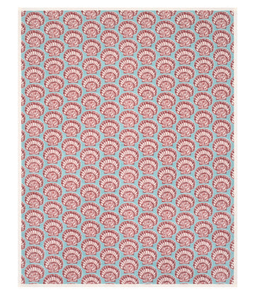 Turquoise blanket with repeating red and white painted shell pattern throughout.7