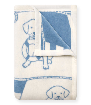 Cream and blue blanket with sailor puppy pattern and white trim, folded to show both sides.6