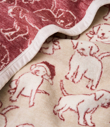 Reversible blanket with burgundy puppies in Santa hats on one side and cream puppies on the other, white binding edge.3