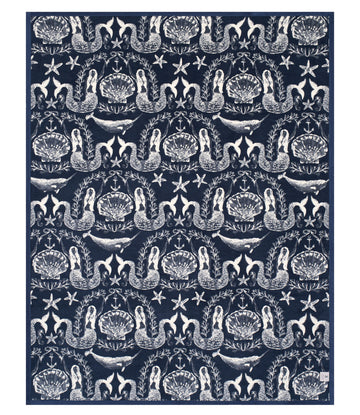 Navy blanket with cream-colored pattern featuring sirens, shells, whales, starfish, and fleur-de-lis motifs.9