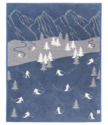 Blue blanket with mountain landscape, ski slope, evergreen trees, and white silhouettes of skiers and snowboarders throughout8