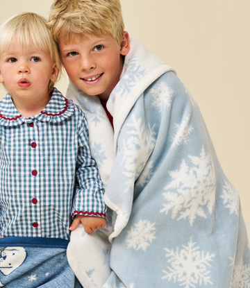 Blue and white midi blanket with snowflake pattern, worn by child over shoulders.3