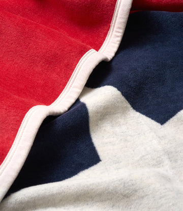 Red, white, and navy blue blanket with white binding along the folded edge showing the Texas flag colors.3