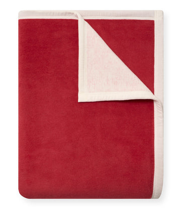 Red and white blanket with a folded corner showing the cream-colored reverse side.4