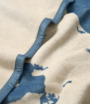 Cream and blue wool blanket with map design and blue binding edge detail.3