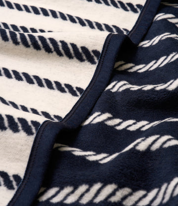 Navy and cream blanket with rope stripe pattern and navy binding along the edge.6