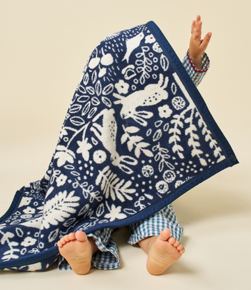 Navy mini blanket with white woodland animals, plants, and geometric patterns.4