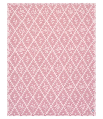 Pink lightweight blanket with white diamond lattice pattern and floral motifs throughout.7